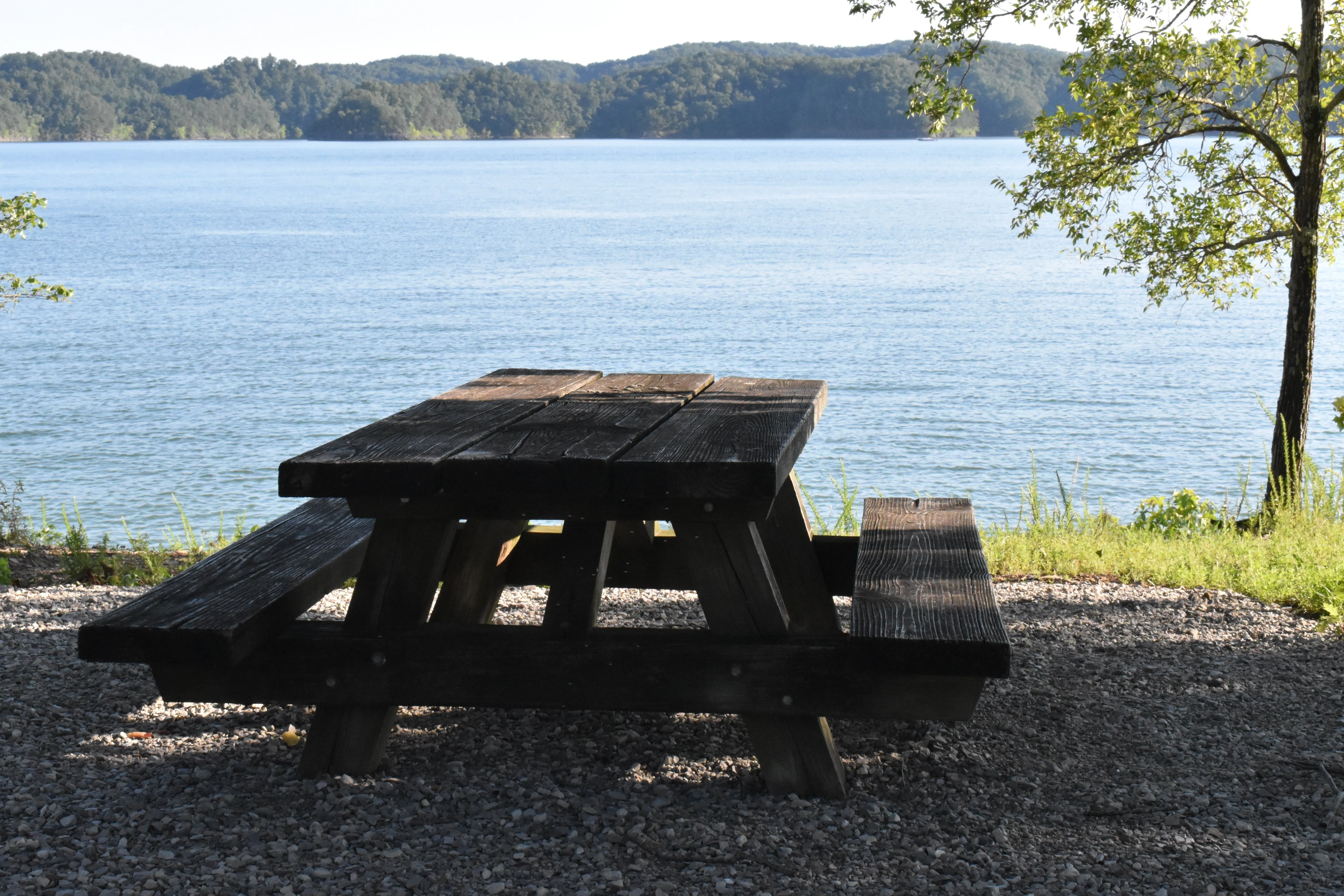 Une table de pique-nique au bord d'un lac. Source Pixabay